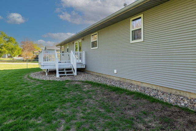 view of grassy yard with a wooden deck