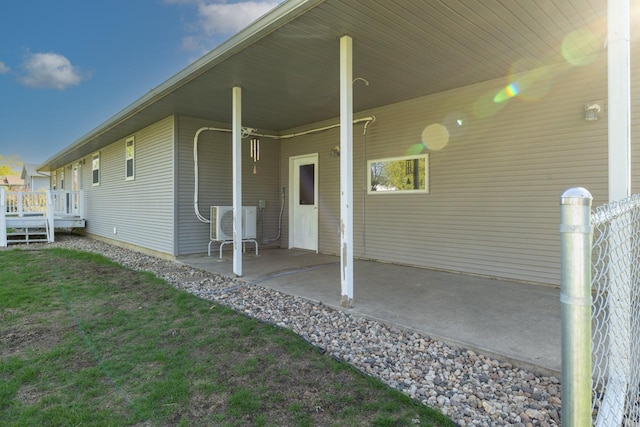 rear view of property featuring an attached carport, ac unit, and a patio