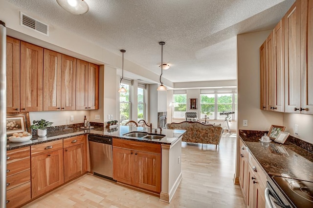 650 Main St N Unit 308, Stillwater, MN 55082 - kitchen featuring dishwasher, a sink, open floor plan, a textured ceiling, and dark stone counters