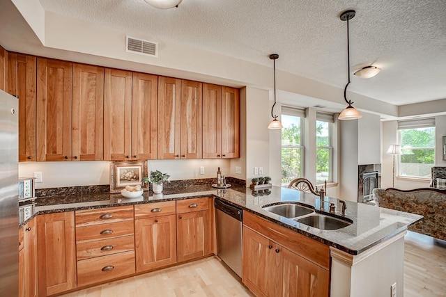 650 Main St N Unit 308, Stillwater, MN 55082 - kitchen with appliances with stainless steel finishes, a sink, light wood-style flooring, dark stone counters, and a textured ceiling
