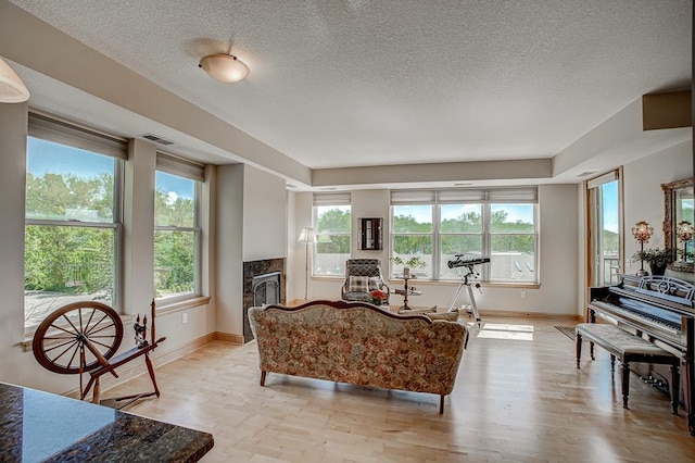 650 Main St N Unit 308, Stillwater, MN 55082 - living room featuring baseboards, a high end fireplace, a textured ceiling, and light wood-style flooring