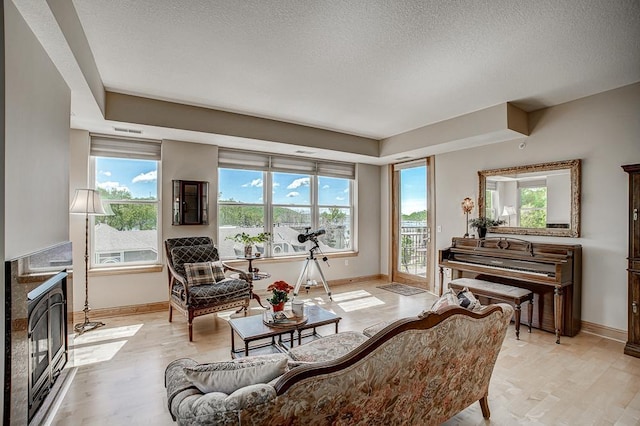 650 Main St N Unit 308, Stillwater, MN 55082 - living room featuring baseboards, a textured ceiling, light wood finished floors, and a high end fireplace