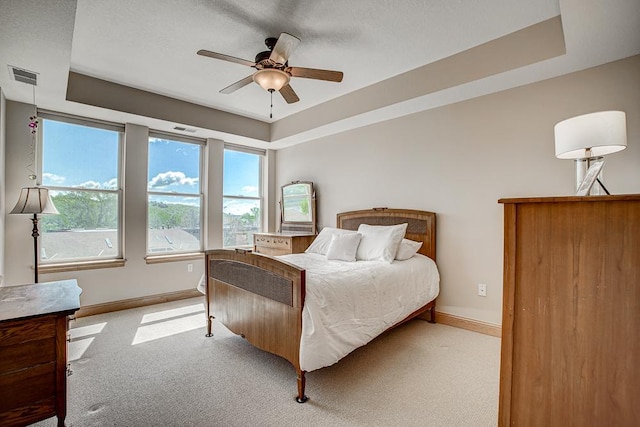 650 Main St N Unit 308, Stillwater, MN 55082 - bedroom featuring light carpet, baseboards, a tray ceiling, and a ceiling fan