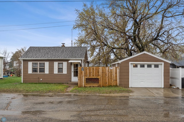 view of front of property with fence, a chimney, a shingled roof, driveway, and a detached garage