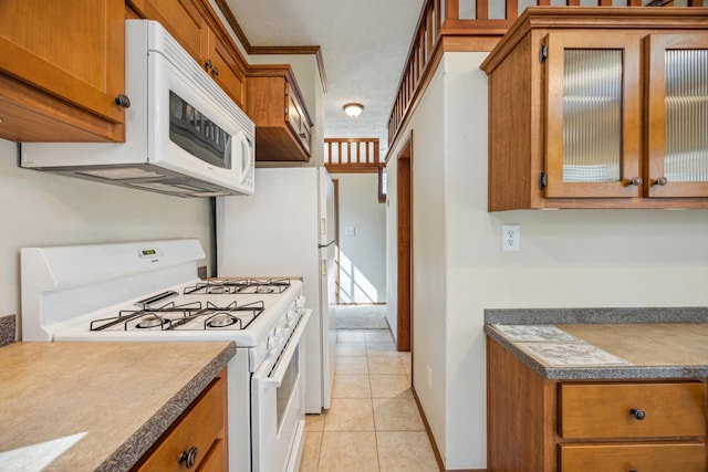 18096 Browns Lake Rd Unit 2, Eden Lake Twp, MN 56368 - kitchen with white appliances, brown cabinets, light tile patterned floors, and glass insert cabinets
