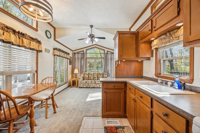 18096 Browns Lake Rd Unit 2, Eden Lake Twp, MN 56368 - kitchen with a sink, brown cabinets, a ceiling fan, light colored carpet, and vaulted ceiling