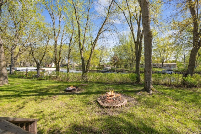 18096 Browns Lake Rd Unit 2, Eden Lake Twp, MN 56368 - view of green lawn with an outdoor fire pit and a water view