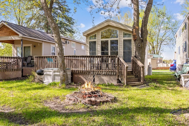 18096 Browns Lake Rd Unit 2, Eden Lake Twp, MN 56368 - back of property featuring an outdoor fire pit, a wooden deck, and a lawn
