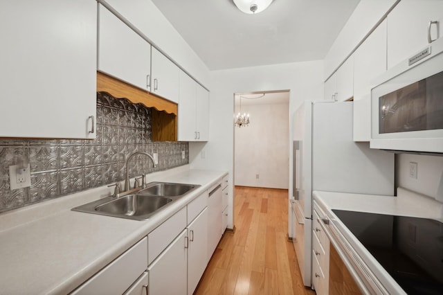 kitchen with white appliances, white cabinets, tasteful backsplash, and light countertops