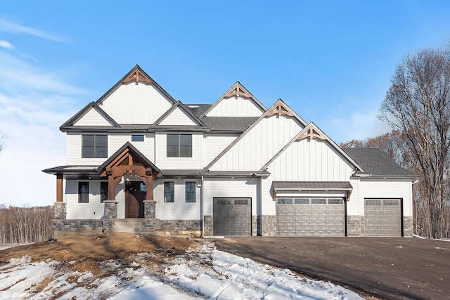 2451 180th Ln NE, Ham Lake, MN 55304 - craftsman-style home featuring stone siding, roof with shingles, board and batten siding, an attached garage, and driveway