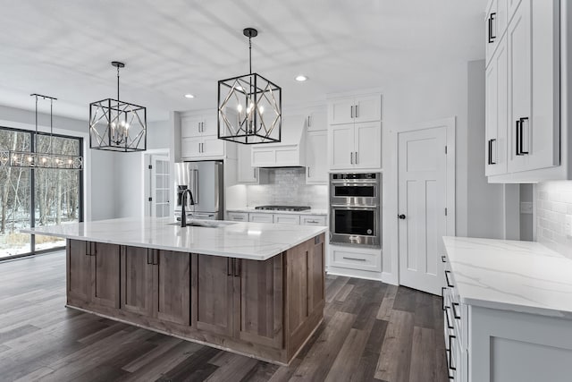 2451 180th Ln NE, Ham Lake, MN 55304 - kitchen with stainless steel appliances, a chandelier, a sink, and tasteful backsplash