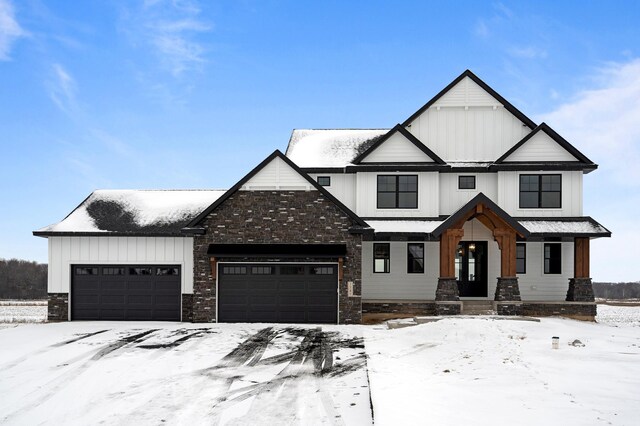 modern inspired farmhouse with an attached garage, board and batten siding, and stone siding