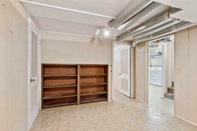 unfinished below grade area with separate washer and dryer, stairs, and tile patterned floors