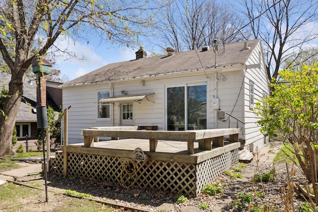 rear view of property featuring a chimney and a deck