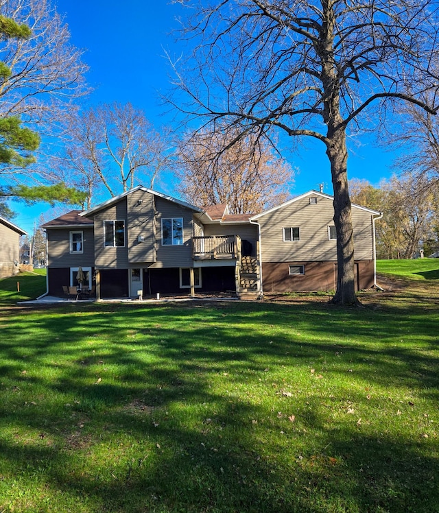 back of property with a lawn and a wooden deck