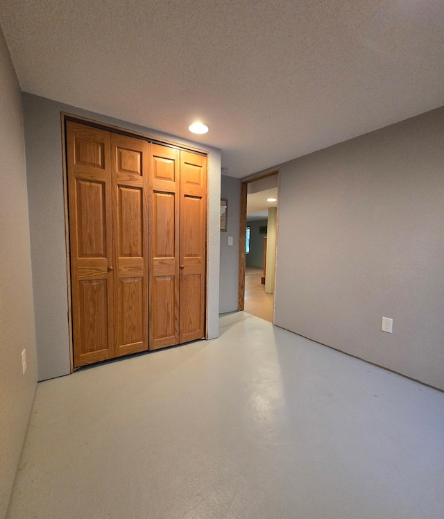 interior space with a textured ceiling, recessed lighting, and finished concrete floors