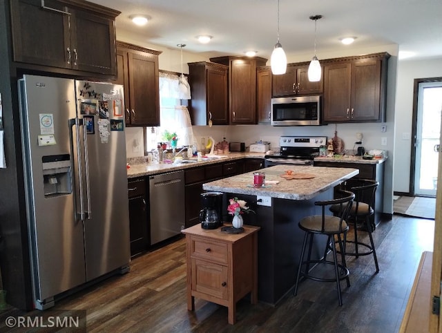 kitchen with dark brown cabinetry, stainless steel appliances, and dark wood-style flooring
