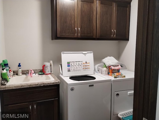 washroom featuring a sink, cabinet space, and washing machine and dryer