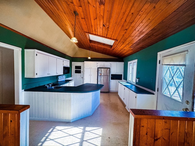 kitchen featuring dark countertops, wooden ceiling, freestanding refrigerator, a peninsula, and lofted ceiling with skylight