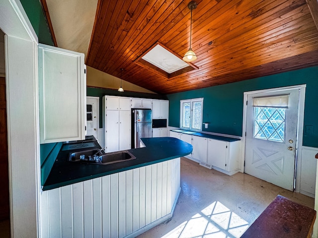 2284 15th St, Johnstown Twp, WI 54826 - kitchen with freestanding refrigerator, a skylight, wooden ceiling, a peninsula, and white cabinets
