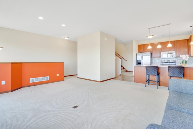 living area featuring light carpet, recessed lighting, baseboards, visible vents, and stairway