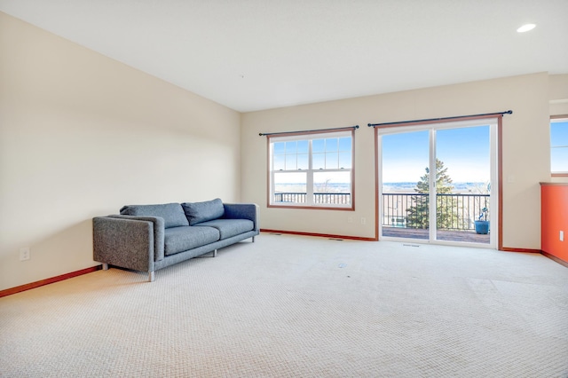 living area with recessed lighting, baseboards, and light carpet