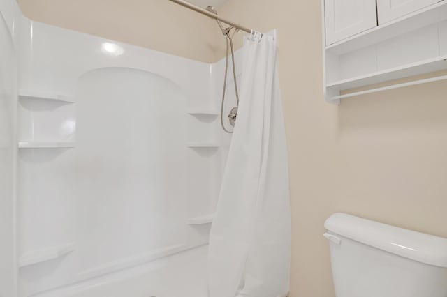 bathroom with toilet and a shower stall