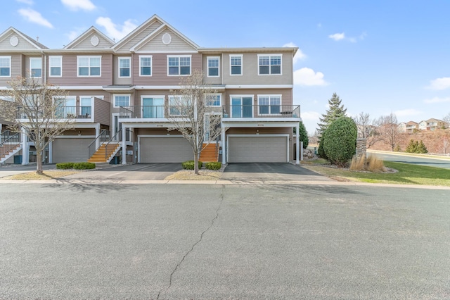 multi unit property with a garage, stairs, and driveway