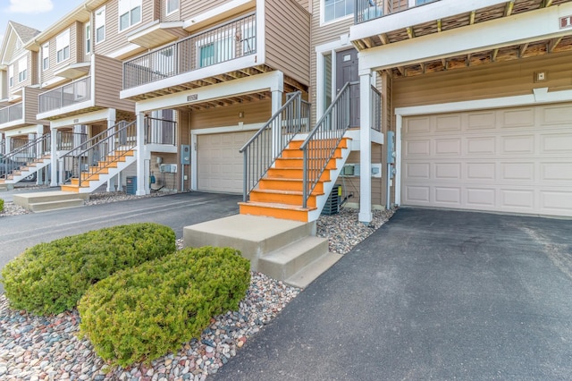 property entrance with an attached garage and aphalt driveway
