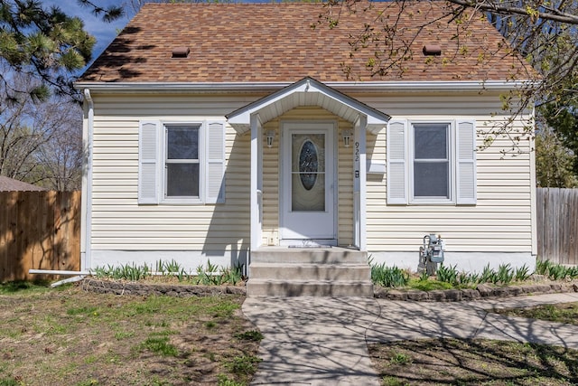 view of front of property featuring fence and roof with shingles