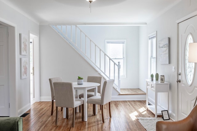 dining room with baseboards, stairs, and wood finished floors