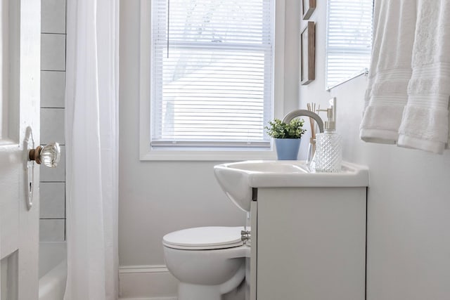 bathroom featuring vanity, shower / bath combo, and toilet