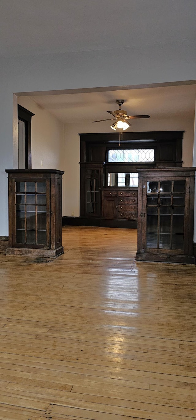 unfurnished living room with ceiling fan and light wood-style flooring