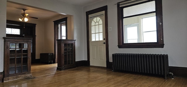 entrance foyer featuring radiator heating unit, ceiling fan, and wood finished floors