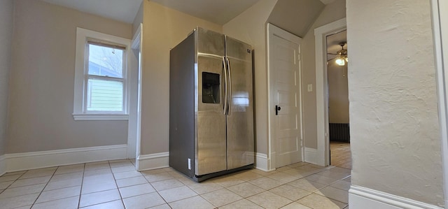 hallway with light tile patterned floors, baseboards, and a textured wall