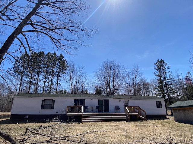 rear view of property featuring a wooden deck