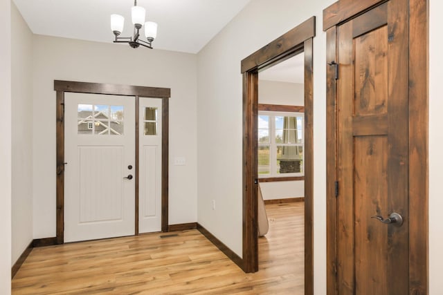 12891 Xylite St NE, Blaine, MN 55449 - entryway featuring baseboards, light wood-style flooring, and an inviting chandelier