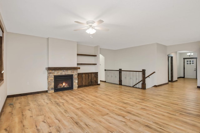 12891 Xylite St NE, Blaine, MN 55449 - unfurnished living room featuring arched walkways, ceiling fan, baseboards, and light wood finished floors