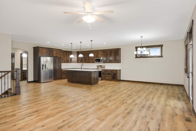 12891 Xylite St NE, Blaine, MN 55449 - kitchen featuring light countertops, appliances with stainless steel finishes, dark brown cabinetry, and arched walkways