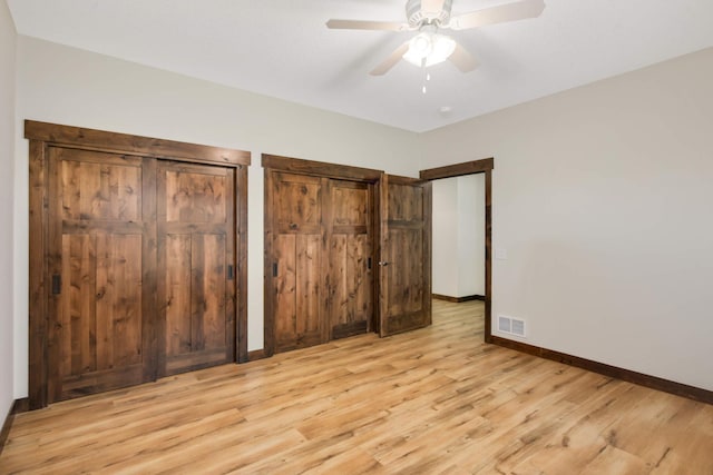 12891 Xylite St NE, Blaine, MN 55449 - unfurnished bedroom featuring two closets, a ceiling fan, baseboards, light wood-type flooring, and visible vents