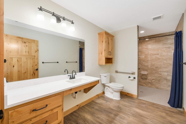 12891 Xylite St NE, Blaine, MN 55449 - bathroom featuring a tile shower, toilet, wood finished floors, and visible vents