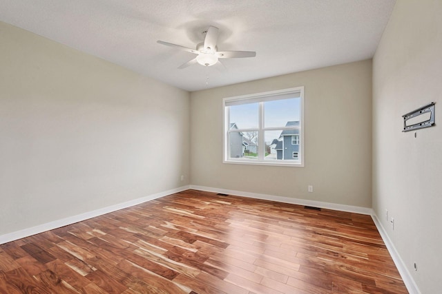 5743 Meridian Way NE, Prior Lake, MN 55372 - spare room with wood finished floors, ceiling fan, baseboards, and a textured ceiling