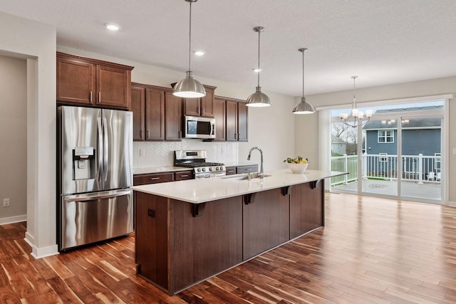 5743 Meridian Way NE, Prior Lake, MN 55372 - kitchen with appliances with stainless steel finishes, a sink, dark wood-style flooring, light countertops, and backsplash