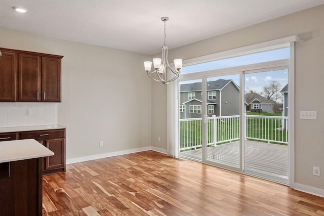 5743 Meridian Way NE, Prior Lake, MN 55372 - unfurnished dining area featuring a chandelier, light wood-type flooring, baseboards, and recessed lighting
