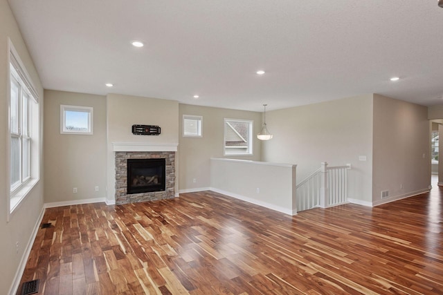 5743 Meridian Way NE, Prior Lake, MN 55372 - unfurnished living room with hardwood / wood-style flooring, healthy amount of natural light, baseboards, a fireplace, and recessed lighting