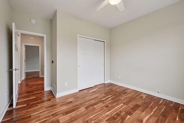 5743 Meridian Way NE, Prior Lake, MN 55372 - unfurnished bedroom with wood finished floors, a closet, baseboards, and a ceiling fan