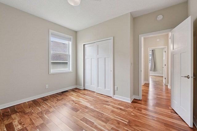 5743 Meridian Way NE, Prior Lake, MN 55372 - unfurnished bedroom featuring light wood-type flooring, a closet, and baseboards