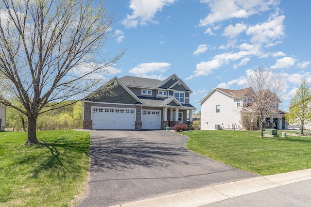 craftsman-style home featuring driveway, an attached garage, a front lawn, and stone siding