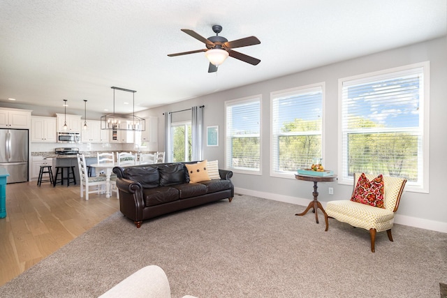 living room featuring a ceiling fan, baseboards, recessed lighting, and light wood-type flooring