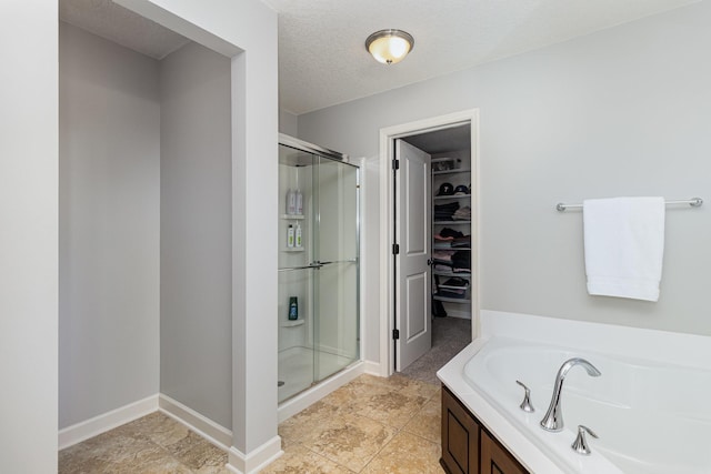 full bath featuring a stall shower, a walk in closet, a bath, baseboards, and tile patterned floors